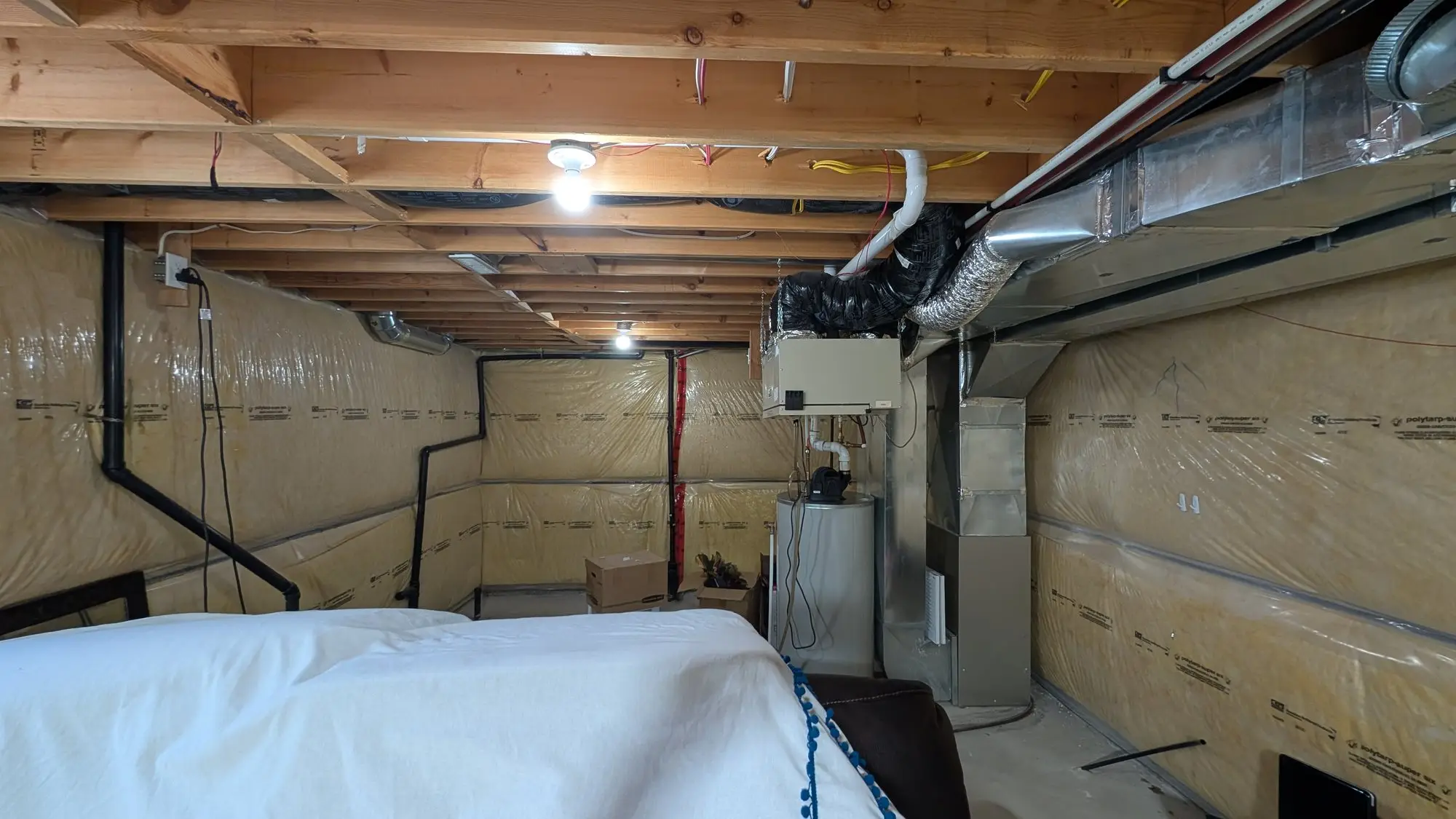 Unfinished basement with exposed joists and insulated stud walls