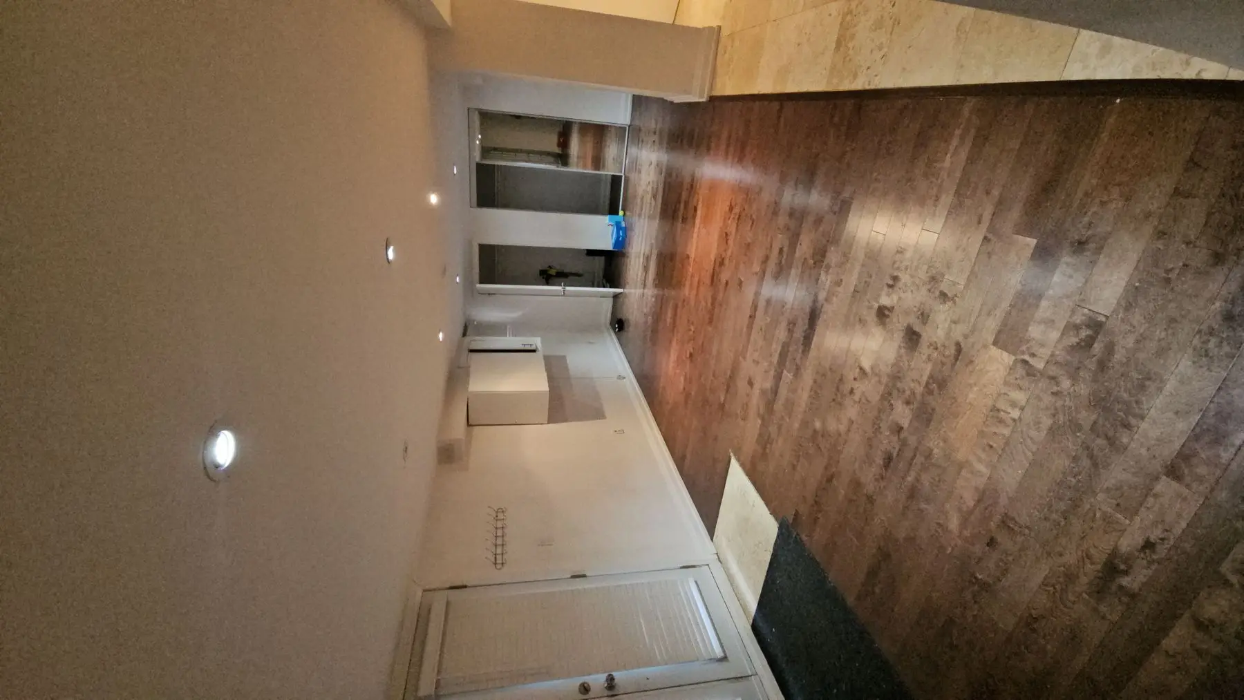 Finished — Finished basement hallway with hardwood flooring and recessed lighting.